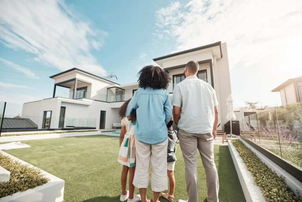new house and family in their backyard together looking at their property or luxury real estate